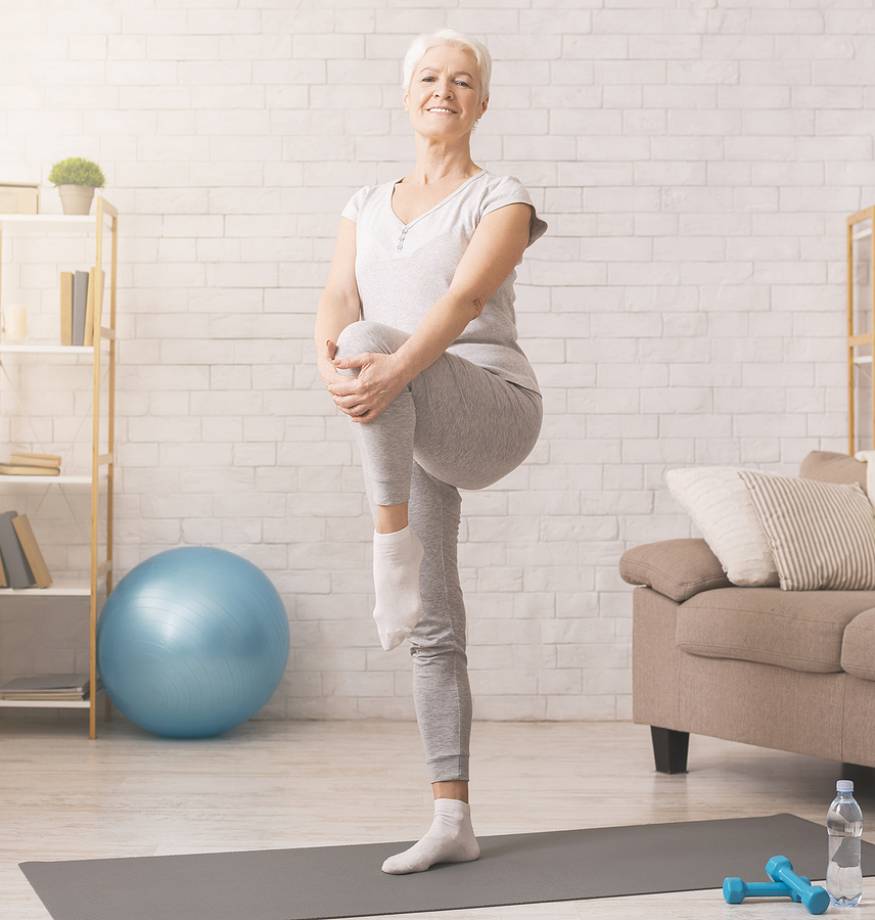 Domestic workout. Cheerful senior woman exercising at home, free space