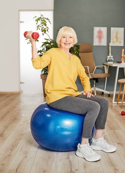Senior,Woman,With,A,Dumbbell,In,Hand,Sitting,On,A